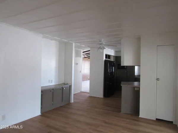 a view of a kitchen with a refrigerator and wooden floor