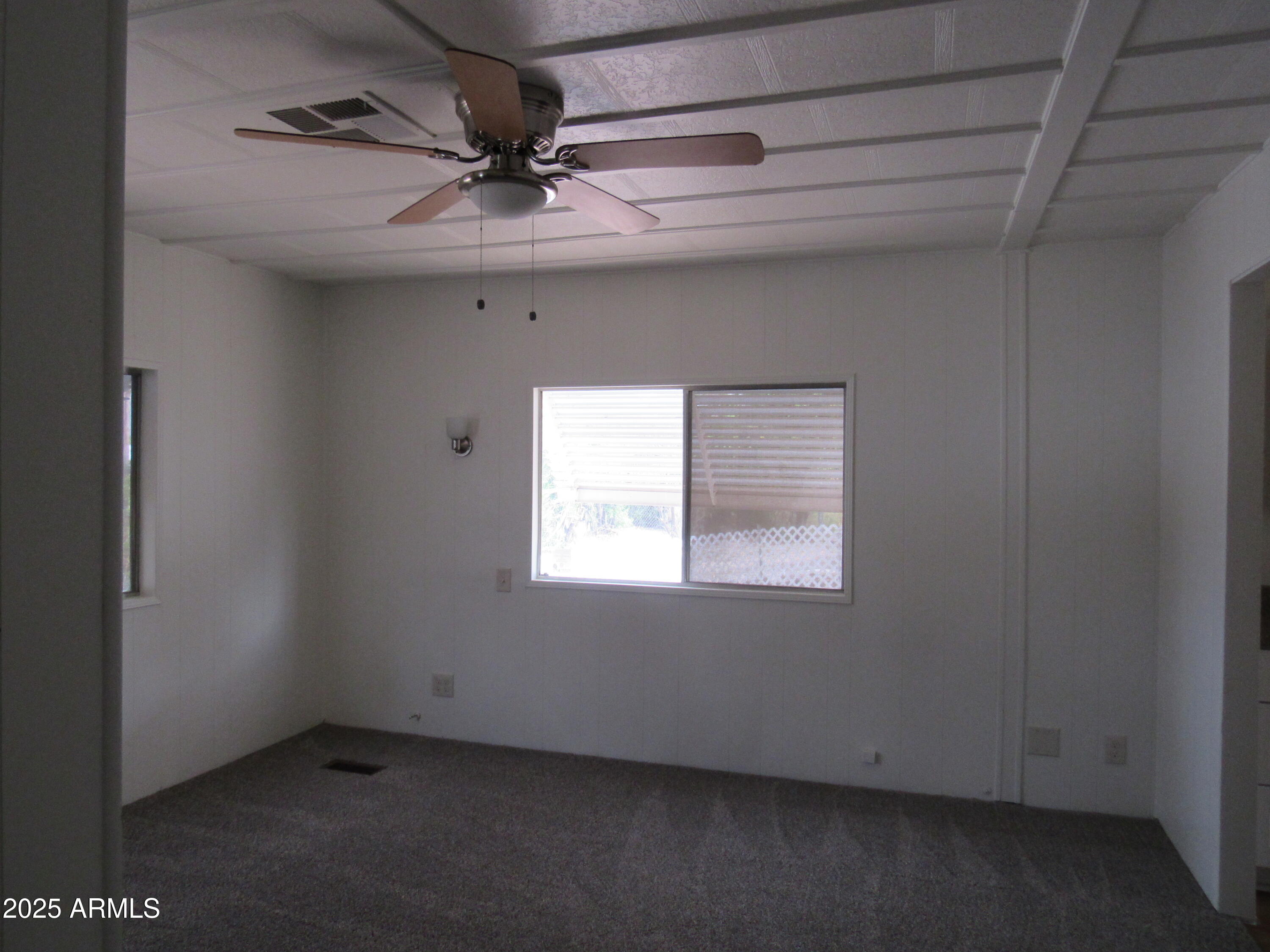 3411 South Camino Seco, Unit 70 Tucson, AZ 85730 - Photo 21 of 22 an empty room with a ceiling fan and window