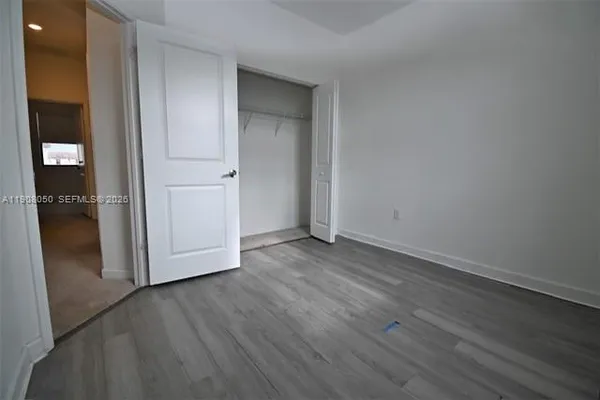 an empty room with wooden floor and closet
