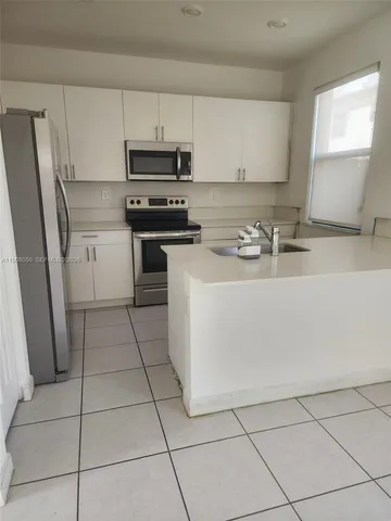 a kitchen with appliances a sink and cabinets