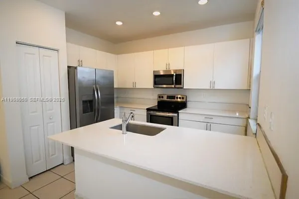 a kitchen with stainless steel appliances a refrigerator sink and microwave