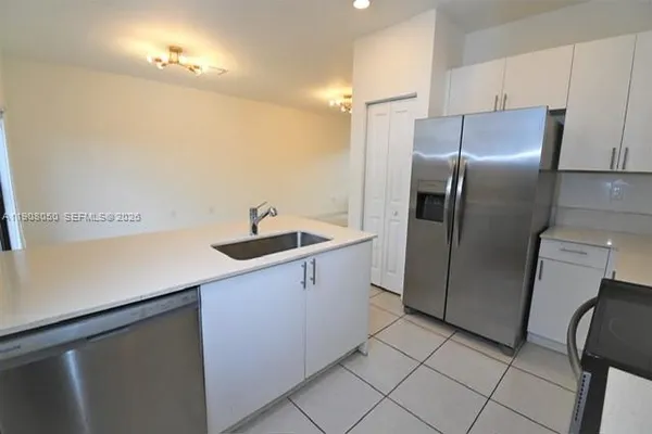a kitchen with stainless steel appliances a refrigerator sink and cabinets