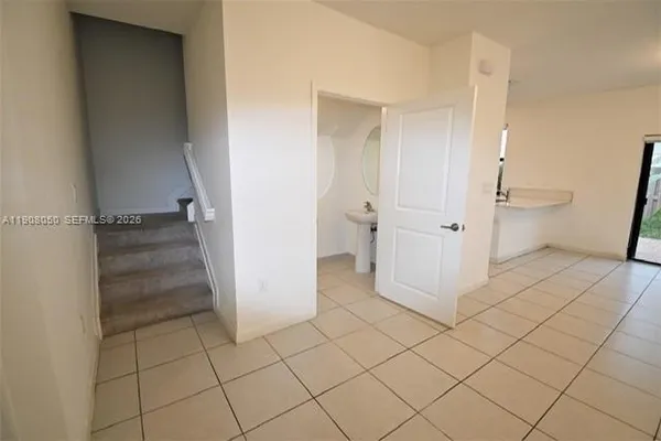 a view of a hallway with closet and a bathroom