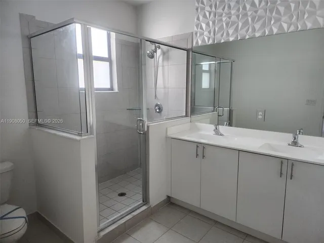 a bathroom with a shower sink vanity and toilet