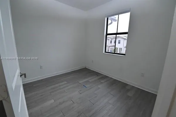 an empty room with windows and closet