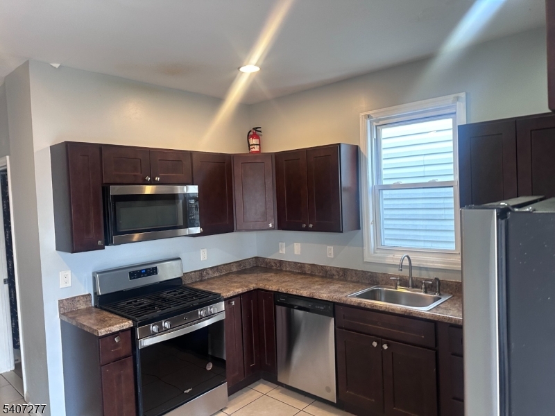 a kitchen with granite countertop a sink stove and microwave