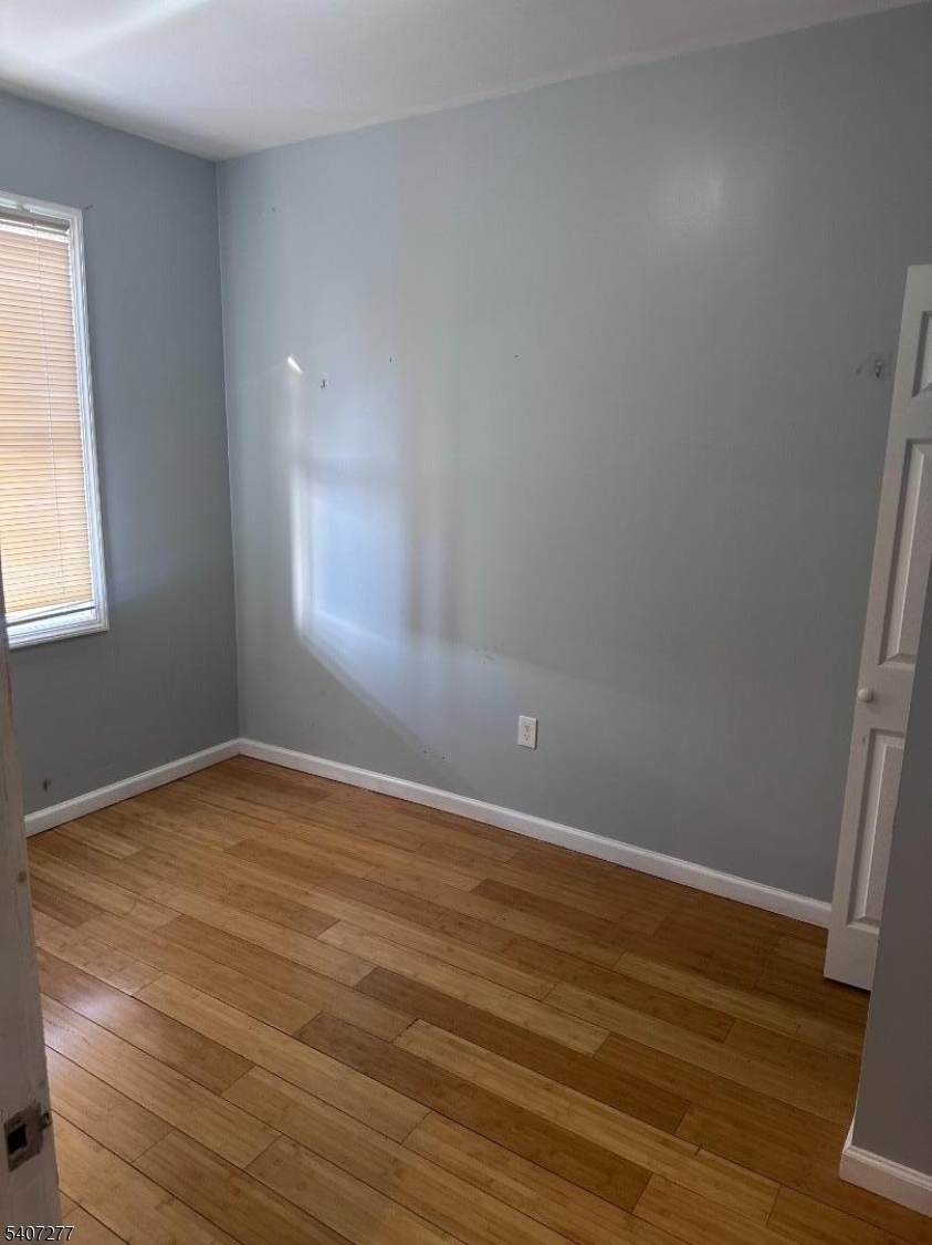 527 South 16th Street Newark, NJ 07103 - Photo 5 of 10 a view of an empty room with wooden floor and a window