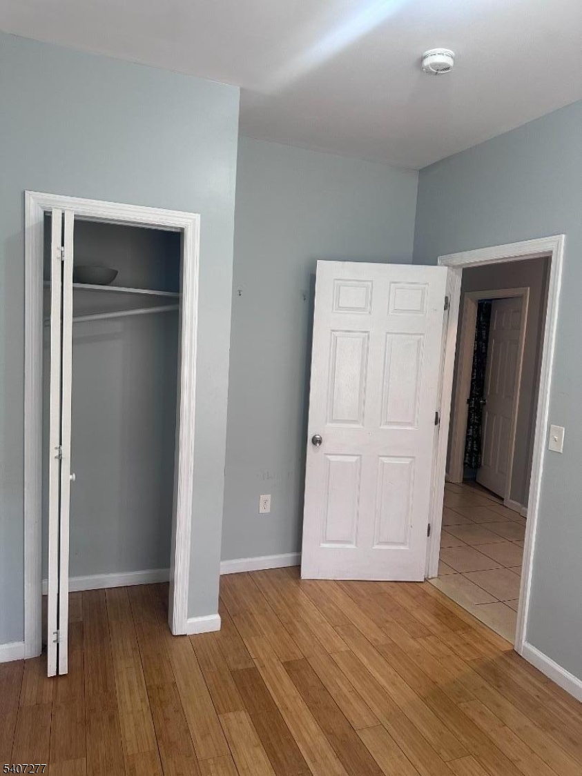 527 South 16th Street Newark, NJ 07103 - Photo 7 of 10 an empty room with wooden floor and closet