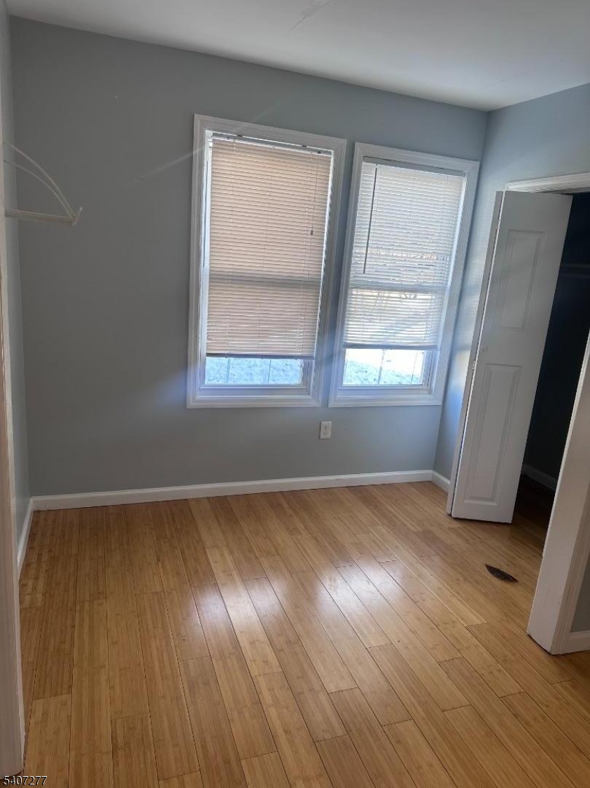 527 South 16th Street Newark, NJ 07103 - Photo 8 of 10 an empty room with wooden floor and windows
