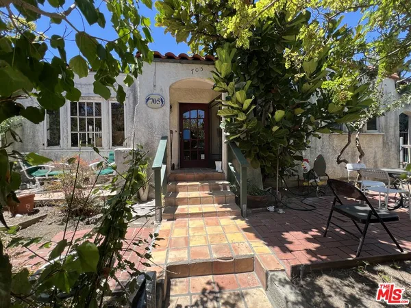 a front view of a house with a tree