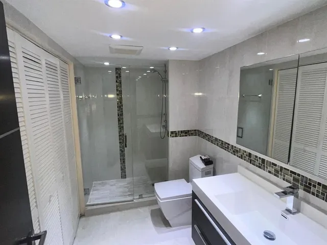 a bathroom with a sink a toilet and shower