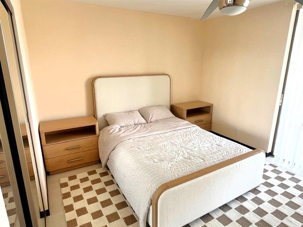 19707 Turnberry Way, Unit 8L Miami, FL 33180 - Photo 15 of 39 a bedroom with a bed and wooden floor