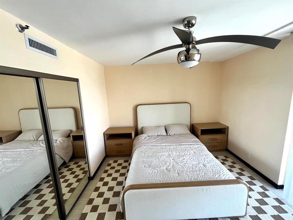 19707 Turnberry Way, Unit 8L Miami, FL 33180 - Photo 16 of 39 a bedroom with a bed and wooden floor