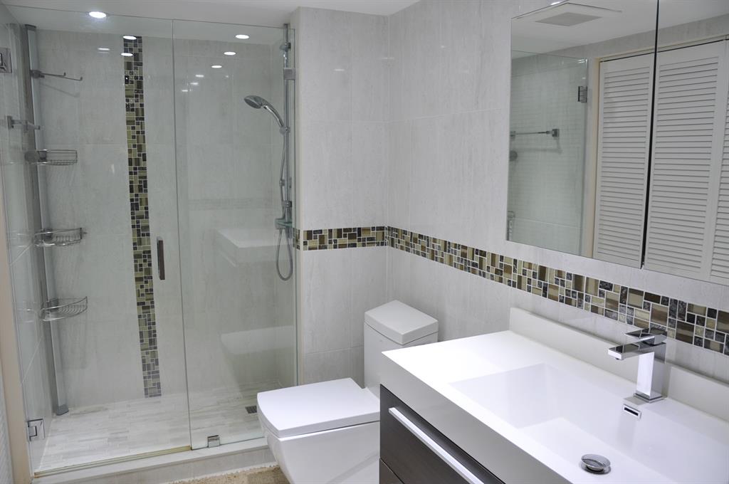 19707 Turnberry Way, Unit 8L Miami, FL 33180 - Photo 21 of 39 a bathroom with a sink a toilet and shower