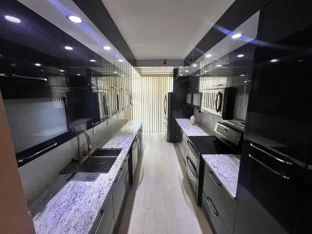 a hallway with couches and dining table with wooden floor