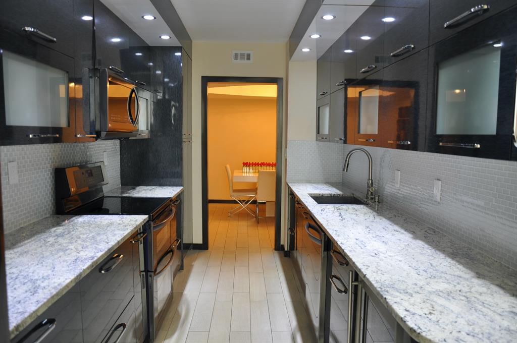 19707 Turnberry Way, Unit 8L Miami, FL 33180 - Photo 6 of 39 a kitchen with stainless steel appliances granite countertop sink stove and refrigerator