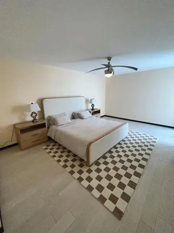 a bedroom with a bed and a ceiling fan