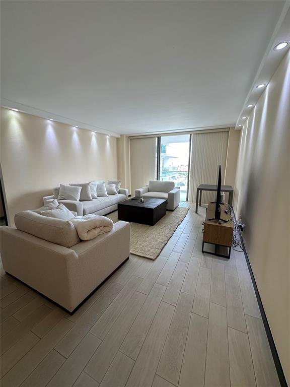 19707 Turnberry Way, Unit 8L Miami, FL 33180 - Photo 10 of 39 a living room with furniture and a wooden floor