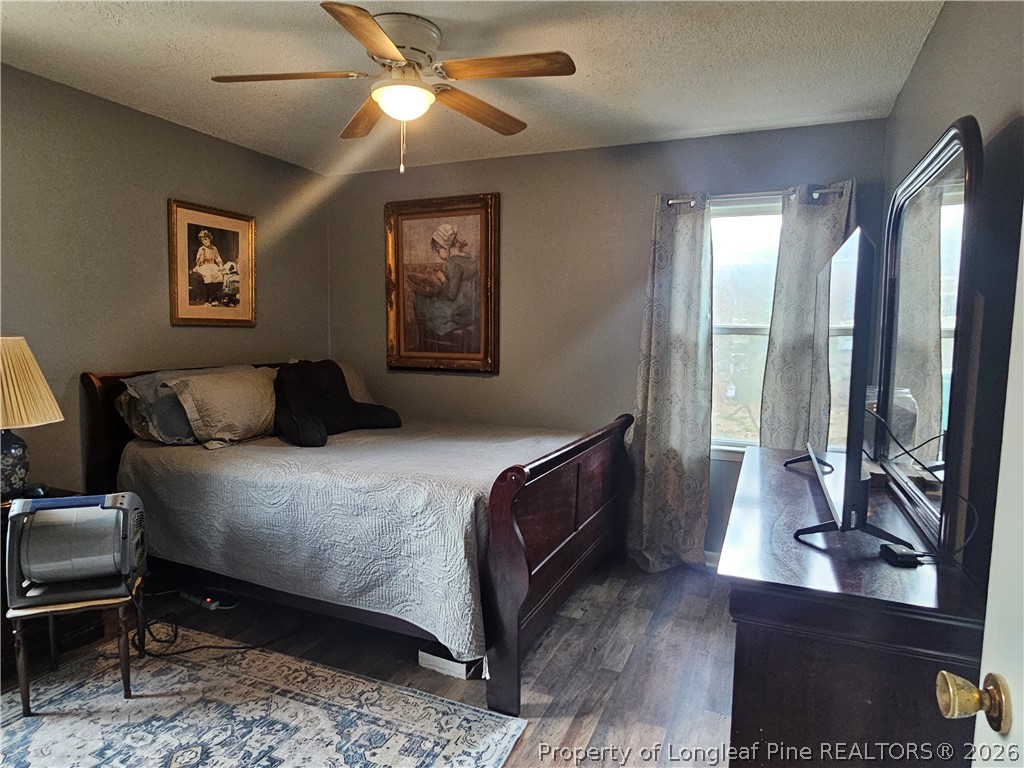 4547 Legion Road Hope Mills, NC 28348 - Photo 18 of 28 a bedroom with a large bed and a chandelier