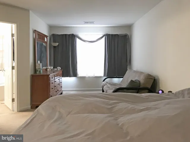 a bedroom with a bed and a large mirror