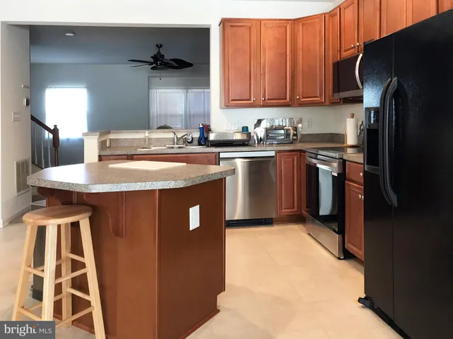 a kitchen with stainless steel appliances granite countertop a refrigerator a stove and a sink