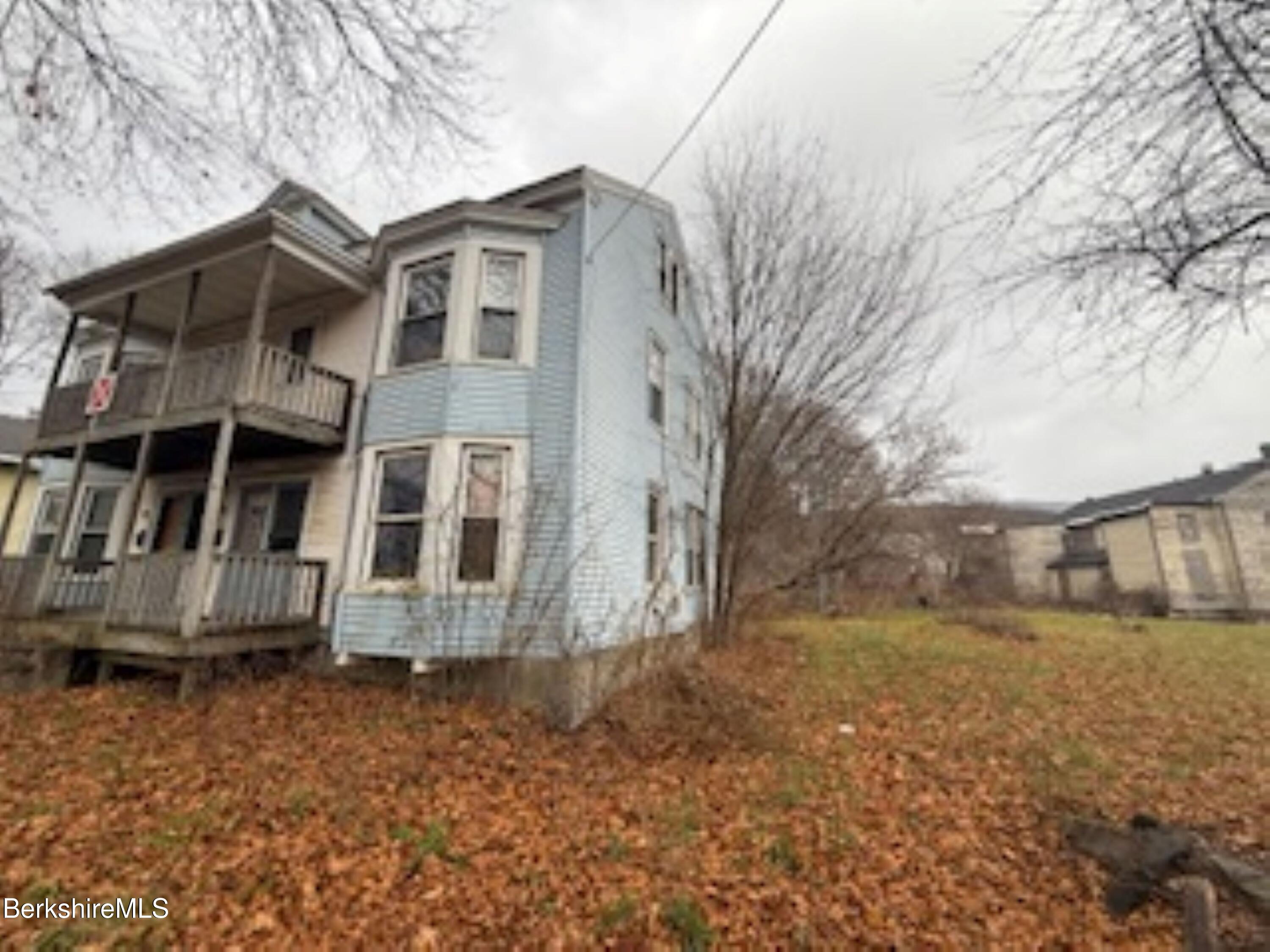 32-38 Spring Street North Adams, MA 01247 - Photo 2 of 32 a view of a brick house with a yard