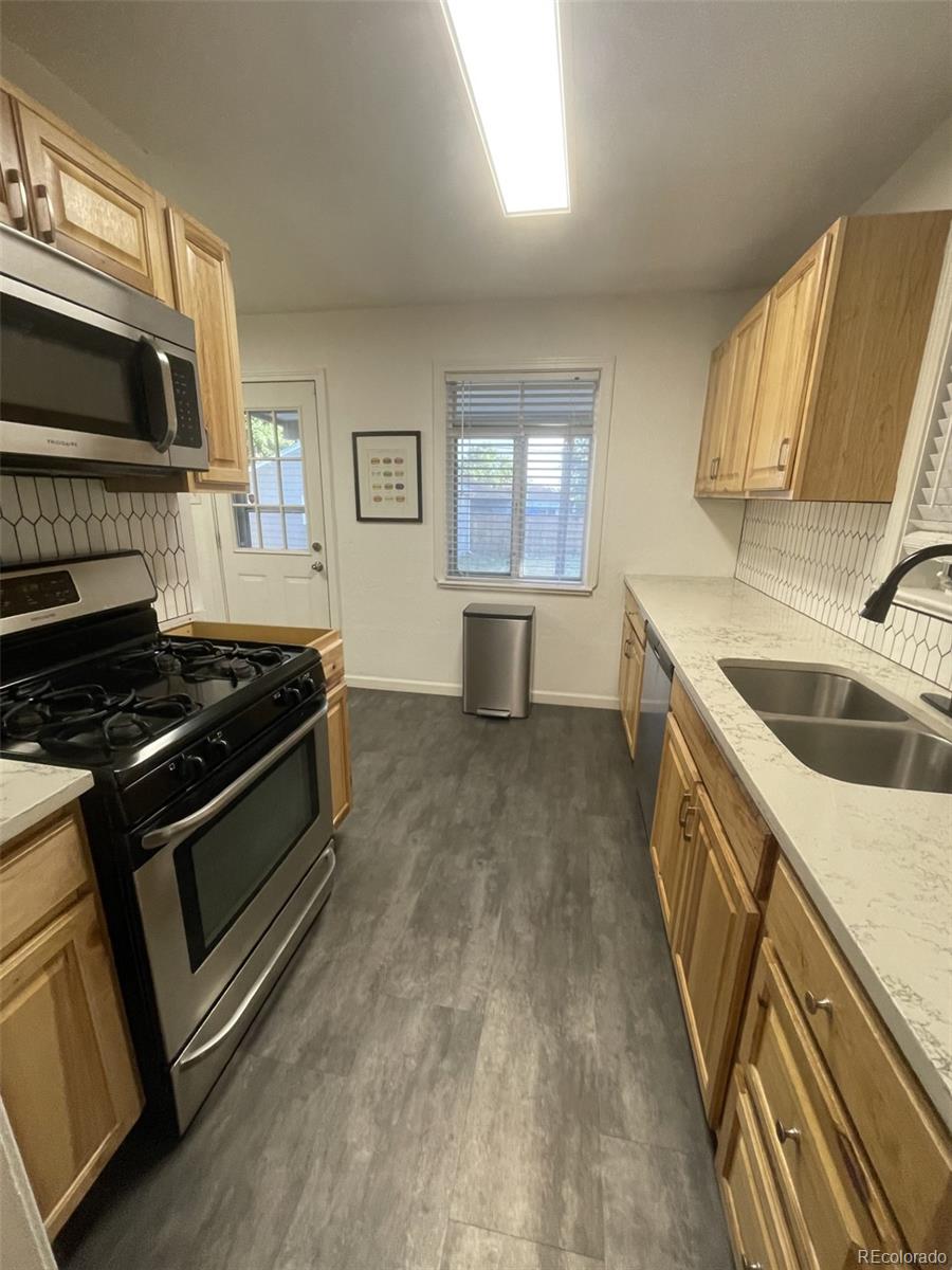 982 South Pecos Way Denver, CO 80223 - Photo 12 of 30 a kitchen that has a sink and a stove top oven