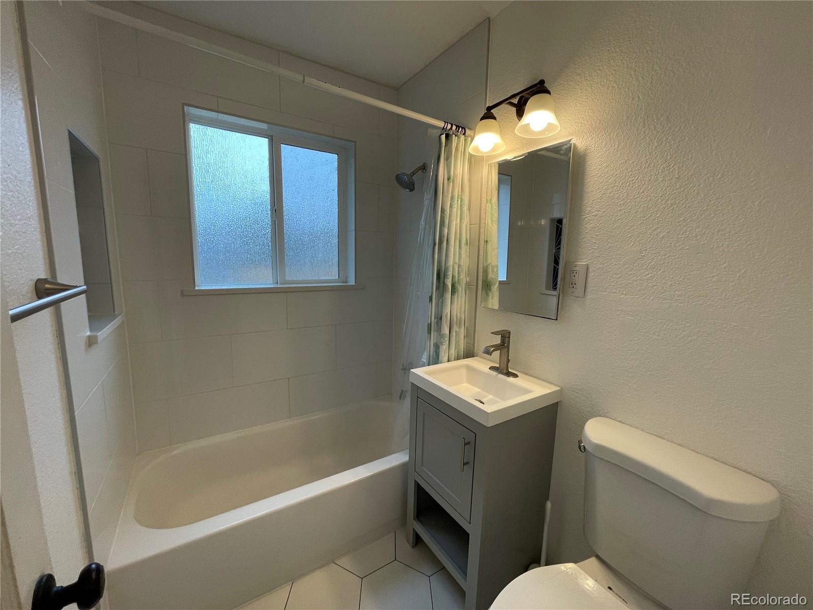 982 South Pecos Way Denver, CO 80223 - Photo 17 of 30 a bathroom with a sink toilet a mirror and bathtub