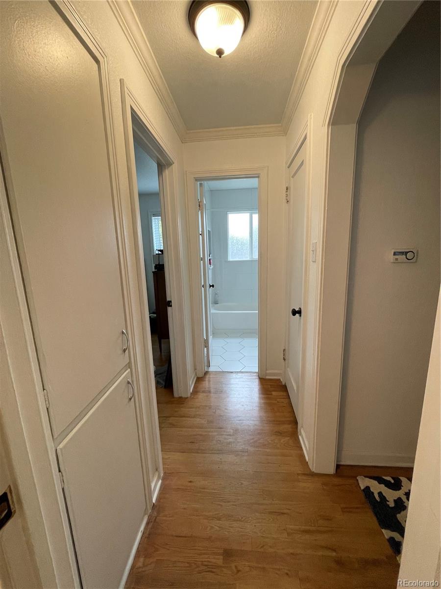 982 South Pecos Way Denver, CO 80223 - Photo 19 of 30 a view of a hallway with wooden floor and closet