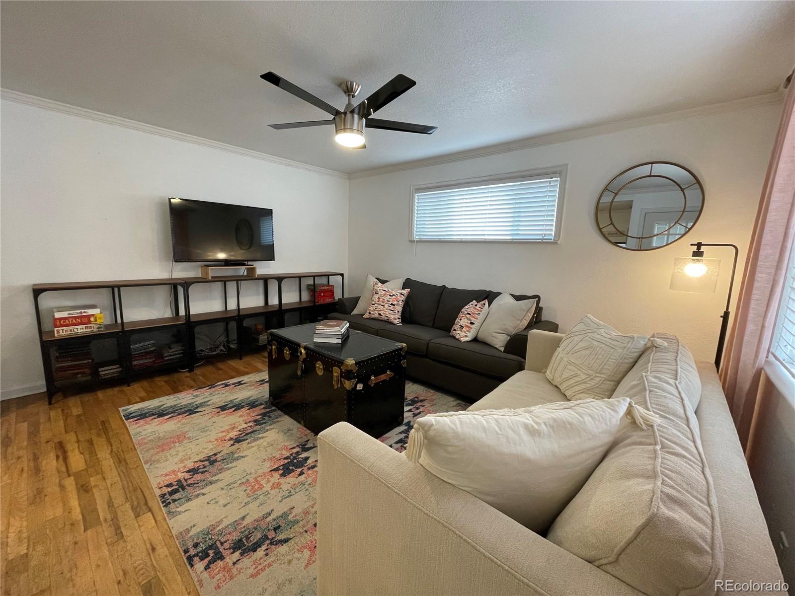 982 South Pecos Way Denver, CO 80223 - Photo 3 of 30 a living room with furniture a flat screen tv and a window
