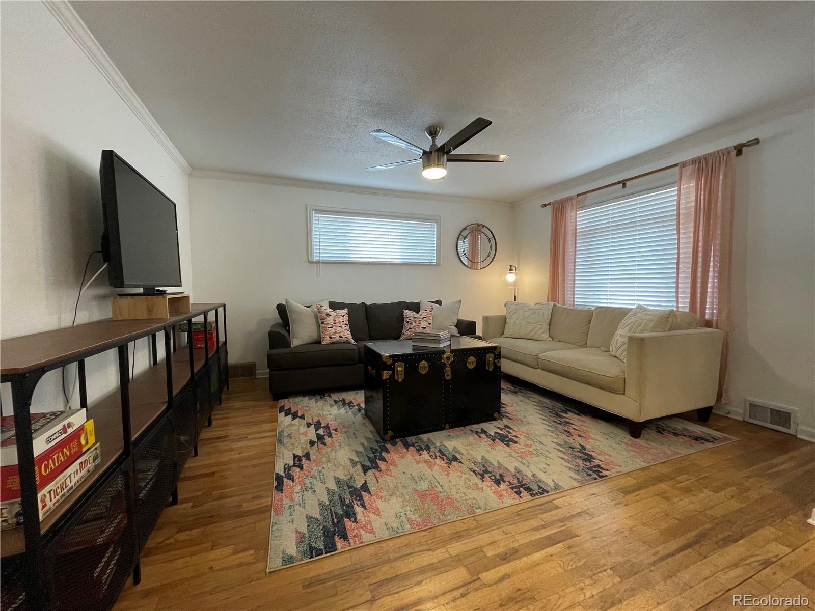 982 South Pecos Way Denver, CO 80223 - Photo 4 of 30 a living room with furniture and a flat screen tv