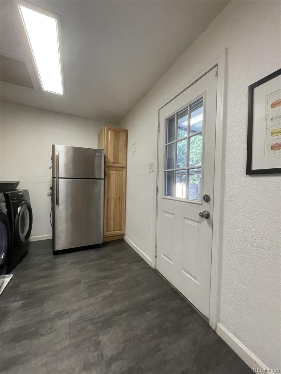 982 South Pecos Way Denver, CO 80223 - Photo 8 of 30 a view of a refrigerator in kitchen and an empty room