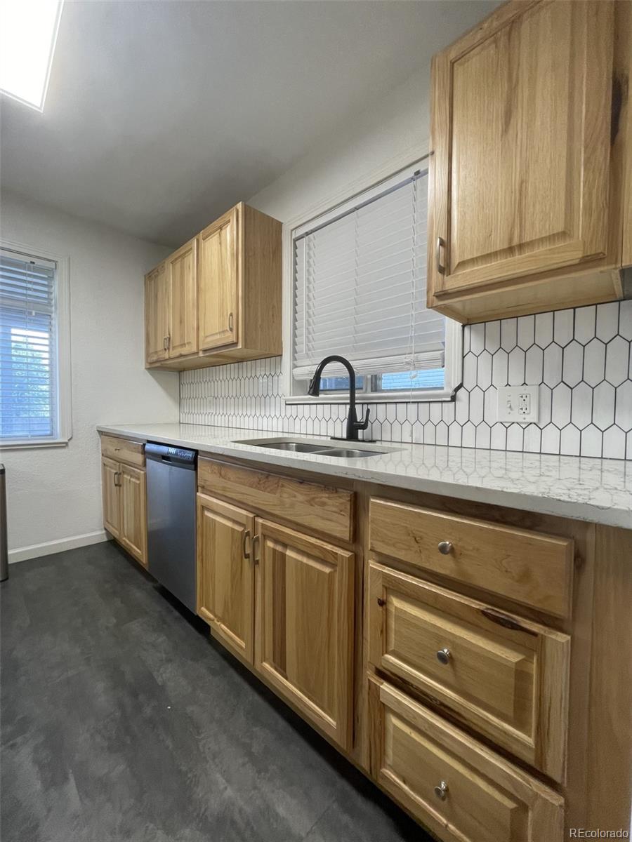 982 South Pecos Way Denver, CO 80223 - Photo 10 of 30 a kitchen with stainless steel appliances granite countertop a sink and cabinets