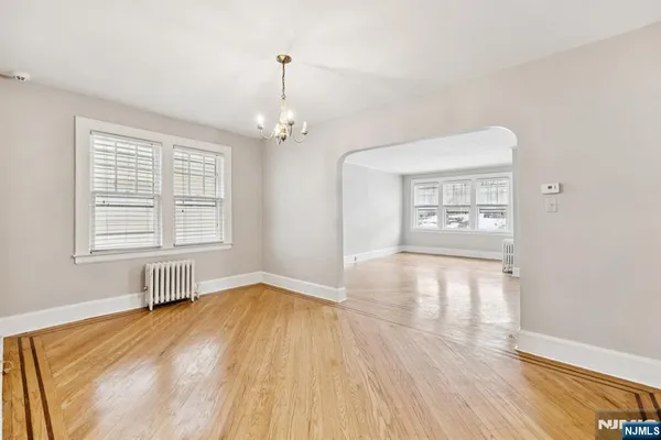 a view of empty room with wooden floor and window