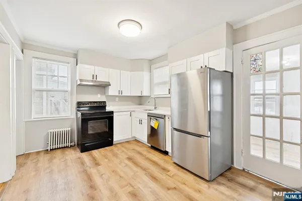 a kitchen with a refrigerator a stove top oven and a window