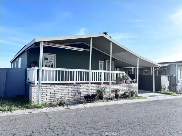 a view of a house with a small yard and wooden fence