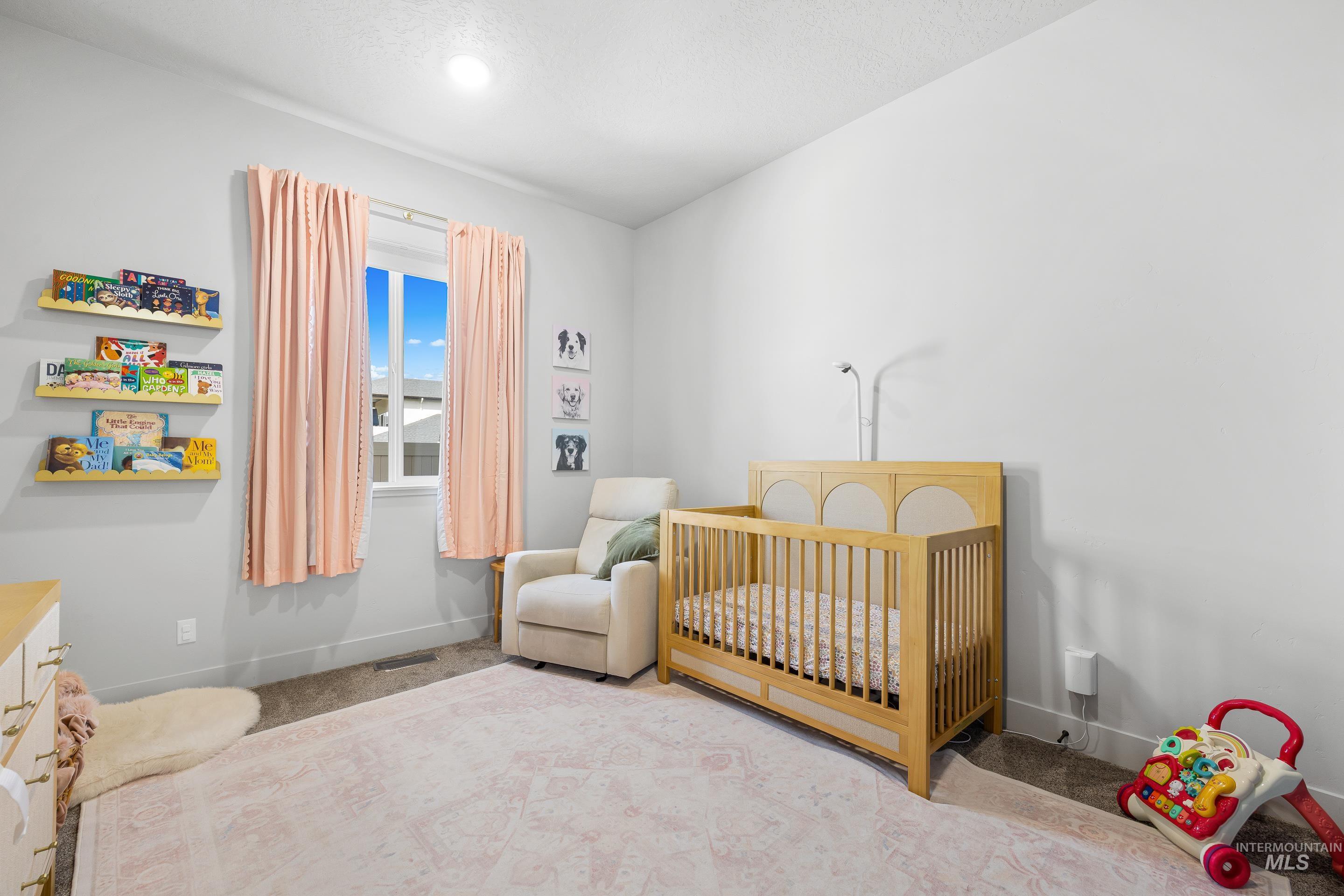 3483 South Grenze Way Meridian, ID 83642 - Photo 20 of 30 Carpeted bedroom featuring a nursery area and baseboards