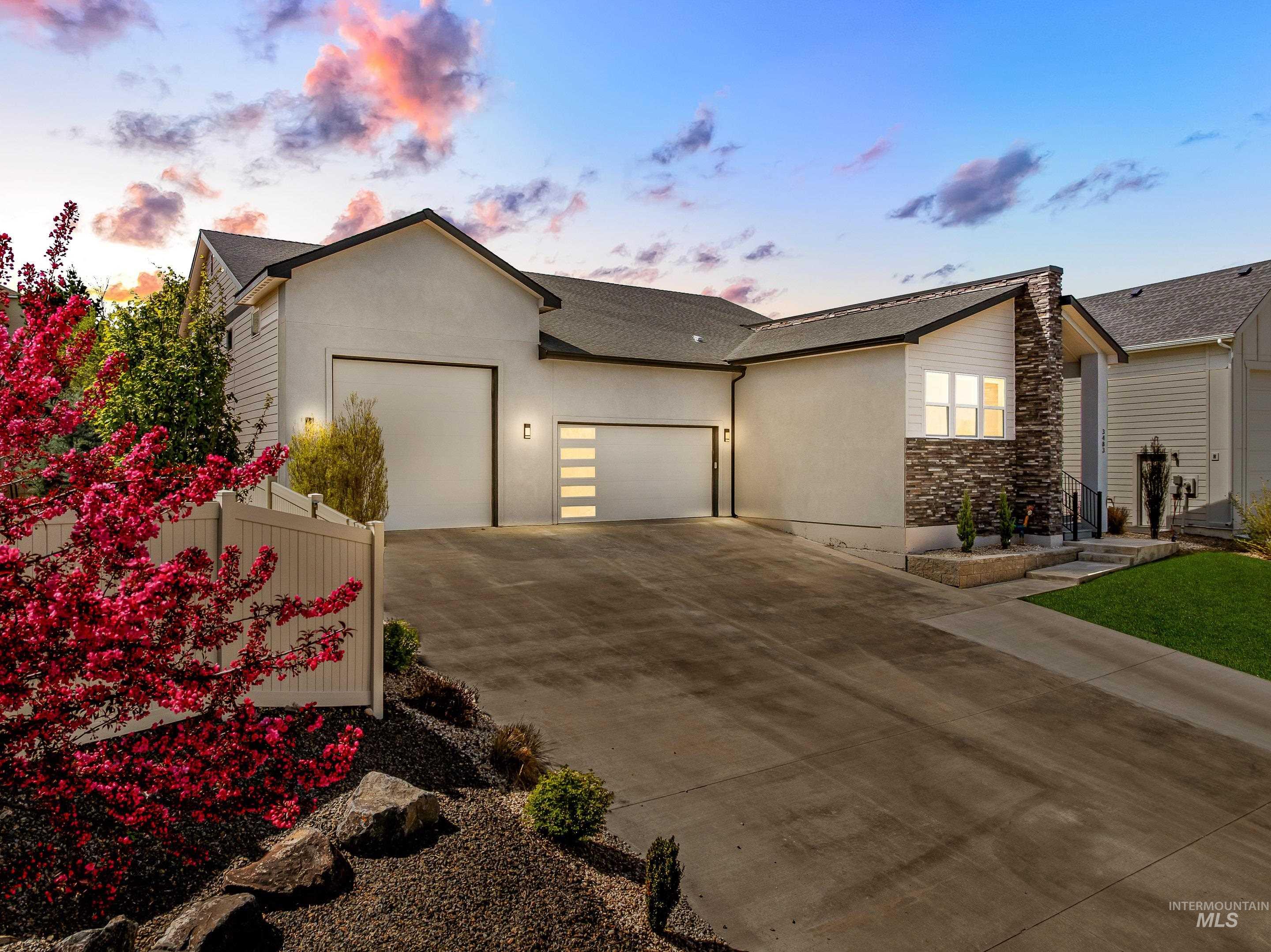 3483 South Grenze Way Meridian, ID 83642 - Photo 2 of 30 View of front of property featuring an attached garage, driveway, stone siding, and stucco siding