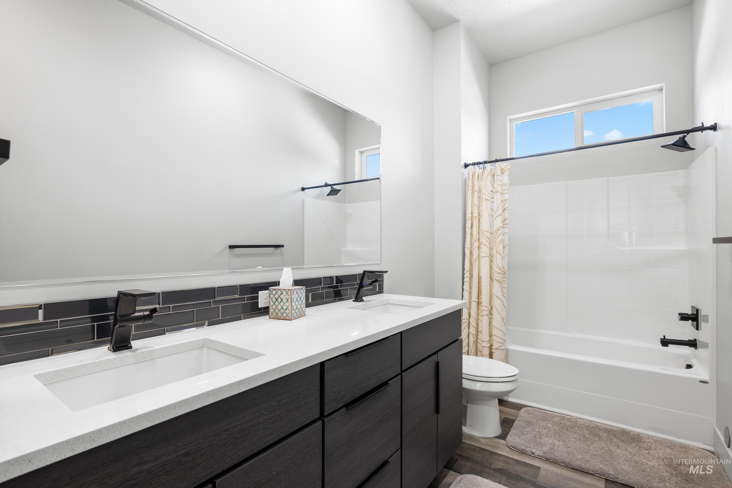 3483 South Grenze Way Meridian, ID 83642 - Photo 22 of 30 Full bathroom with double vanity, dark wood-style flooring, and shower / bathtub combination with curtain