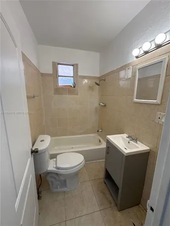a white toilet sitting next to a bathroom sink and tub