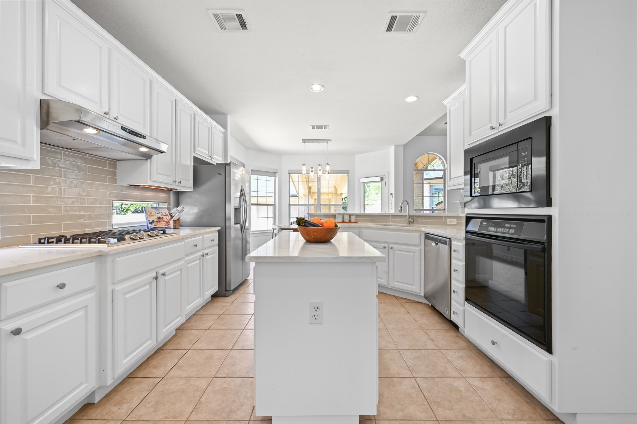 3125 Sun Drenched Path Austin, TX 78732 - Photo 16 of 38 Updated in 2026, the quartz countertops and fresh tile backsplash offer a bright, modern feel