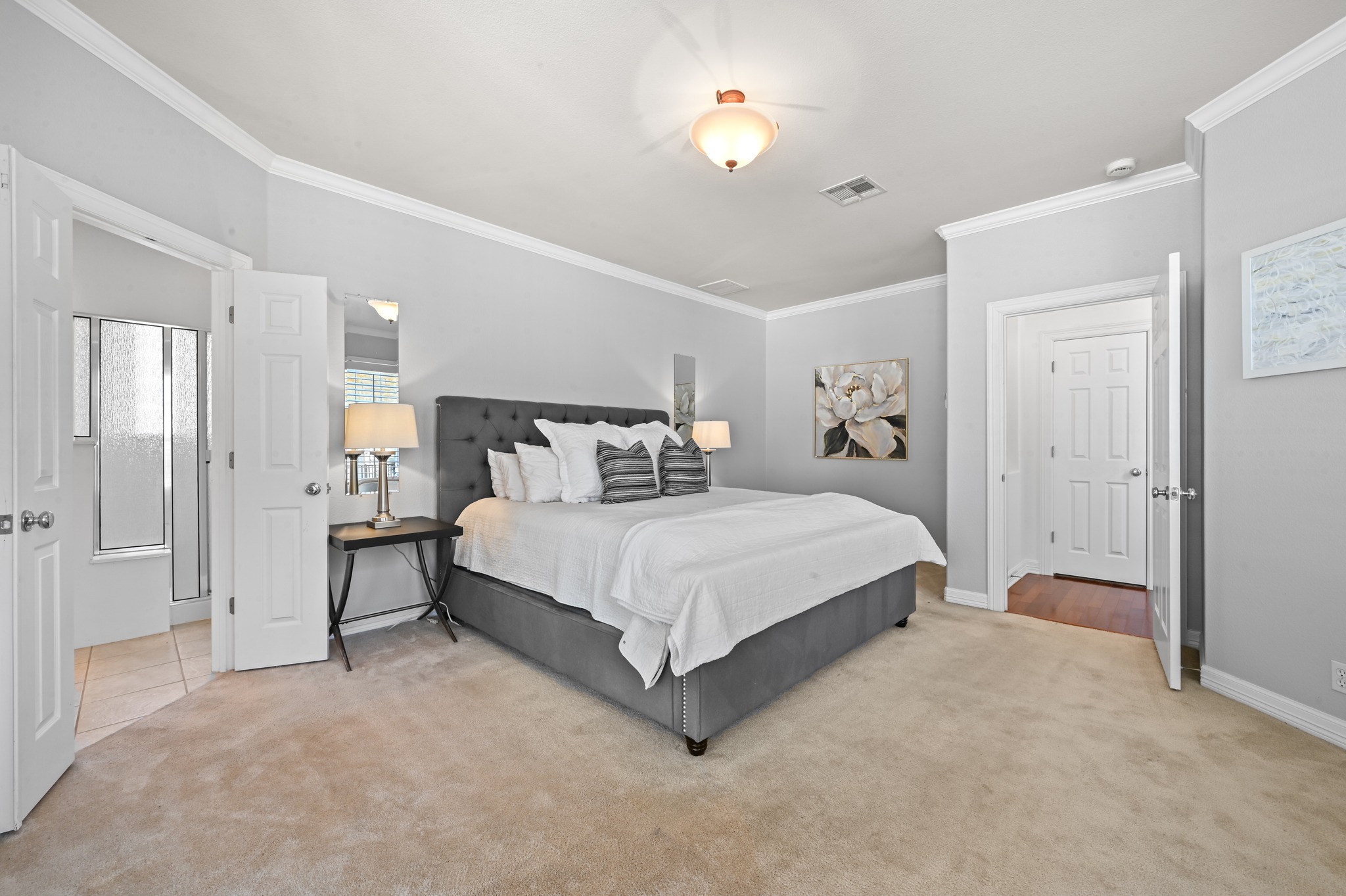 3125 Sun Drenched Path Austin, TX 78732 - Photo 18 of 38 Tucked away on the main level, this oversized primary bedroom offers a quiet spot to unwind with a view of the trees