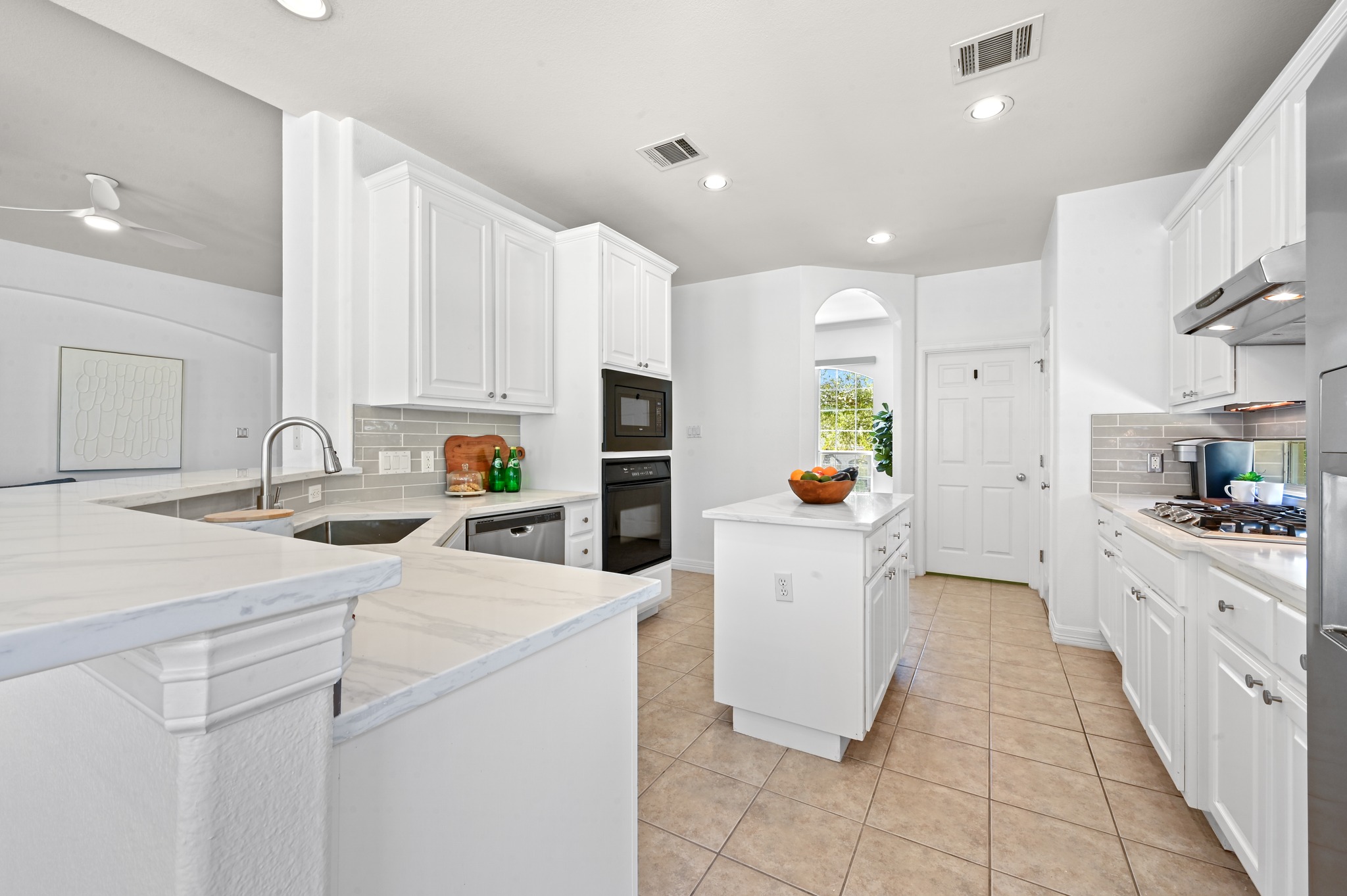 3125 Sun Drenched Path Austin, TX 78732 - Photo 3 of 38 A breakfast bar wraps around the kitchen, providing extra seating and a wide surface for meal prep and serving