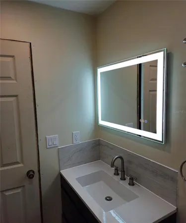 a bathroom with a sink a toilet and mirror