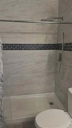 an empty room with wooden floor closet and windows