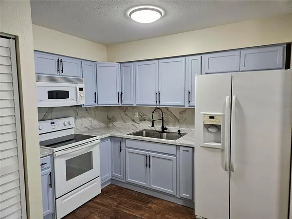 an empty room with wooden floor closet and windows