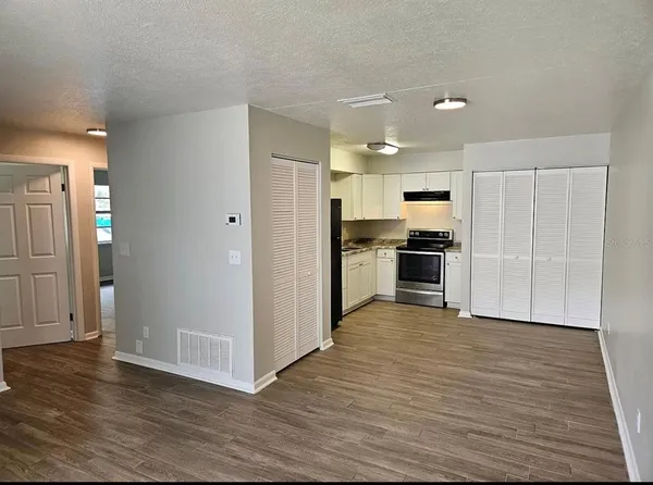 a kitchen with granite countertop white cabinets and black appliances