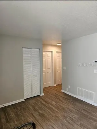 a view of a hallway with wooden floor and stairs