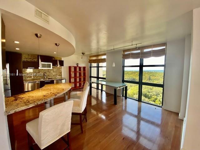 1121 Crandon Boulevard, Unit D802 Key Biscayne, FL 33149 - Photo 15 of 30 a dining room with furniture a rug and wooden floor