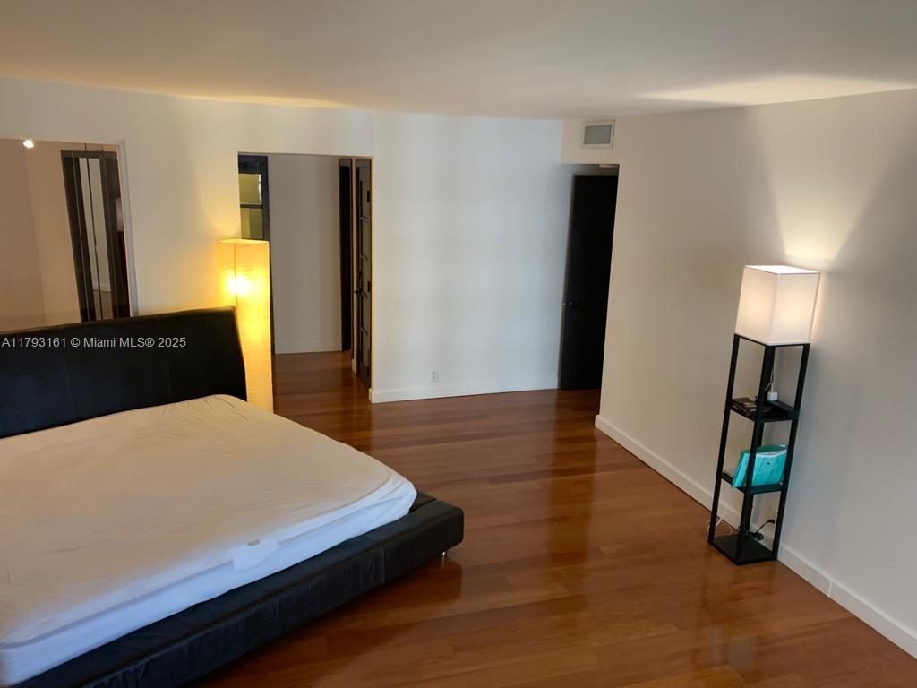 1121 Crandon Boulevard, Unit D802 Key Biscayne, FL 33149 - Photo 25 of 30 a bedroom with a bed and a mirror on dresser